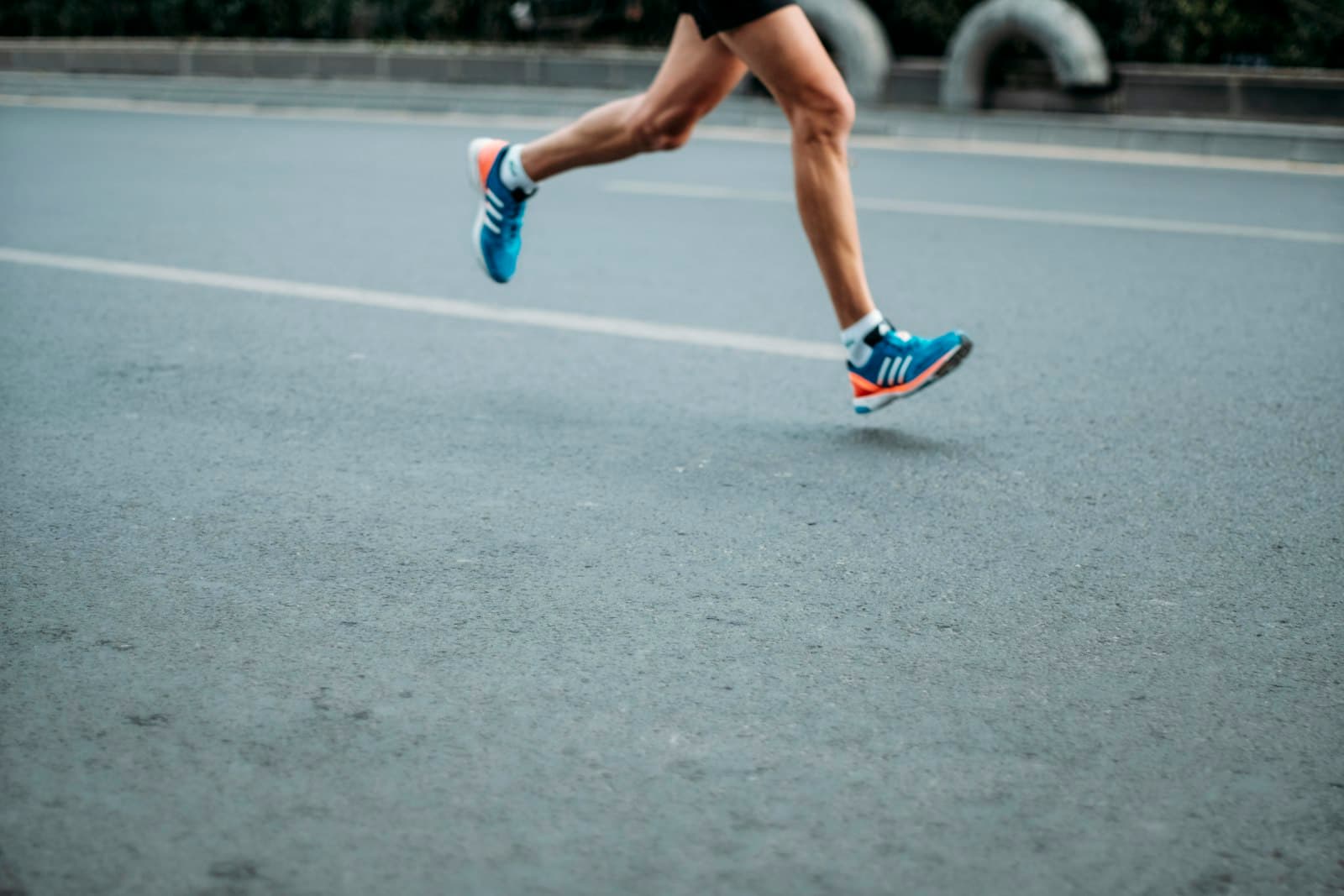 Runner tying shoes on a park path before an easy run